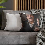 A square throw pillow featuring a printed portrait of a man with a mustache, styled on a gray sofa alongside a plain white pillow and a black-and-white plaid throw blanket.