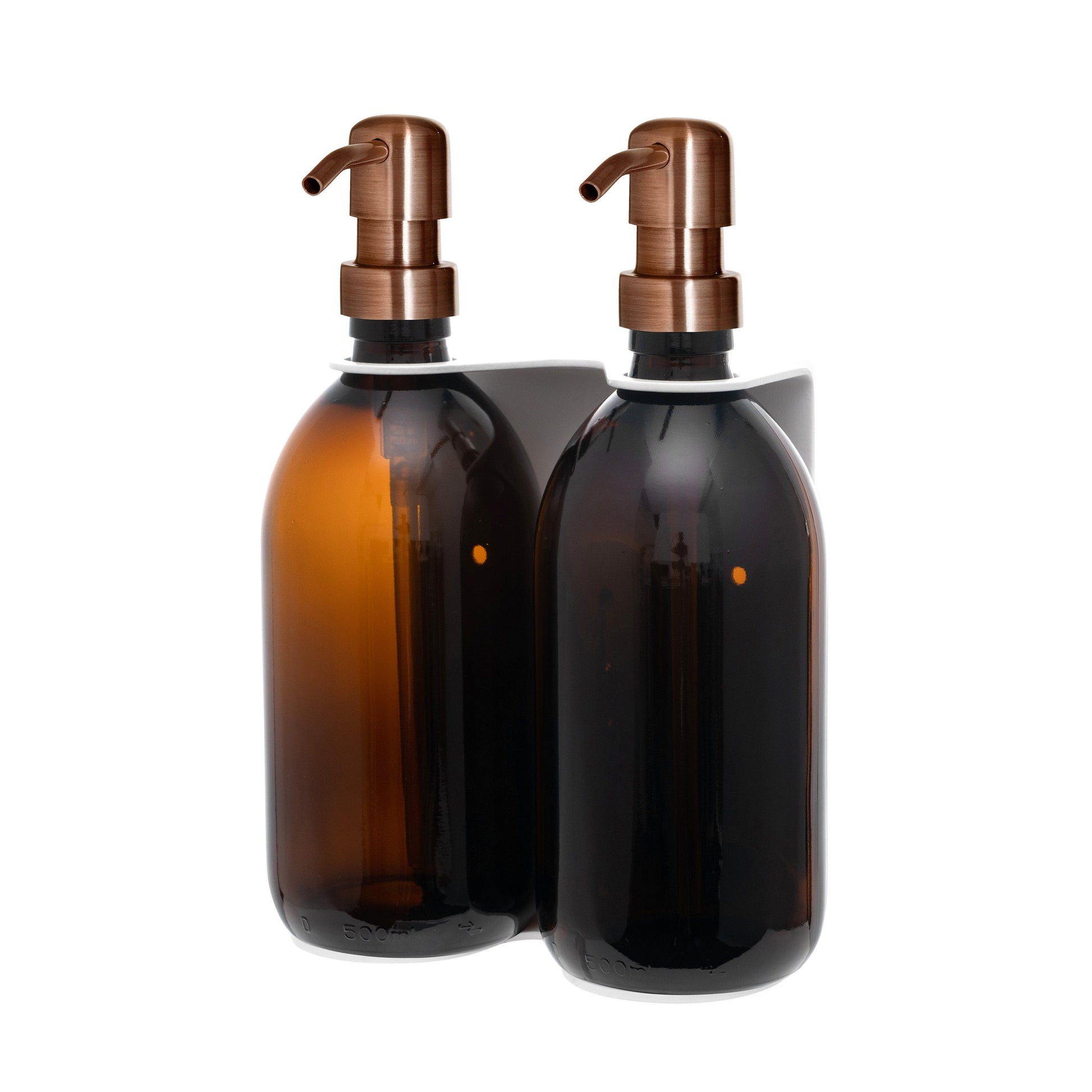 Two amber glass bottles with bronze pumps on a white background