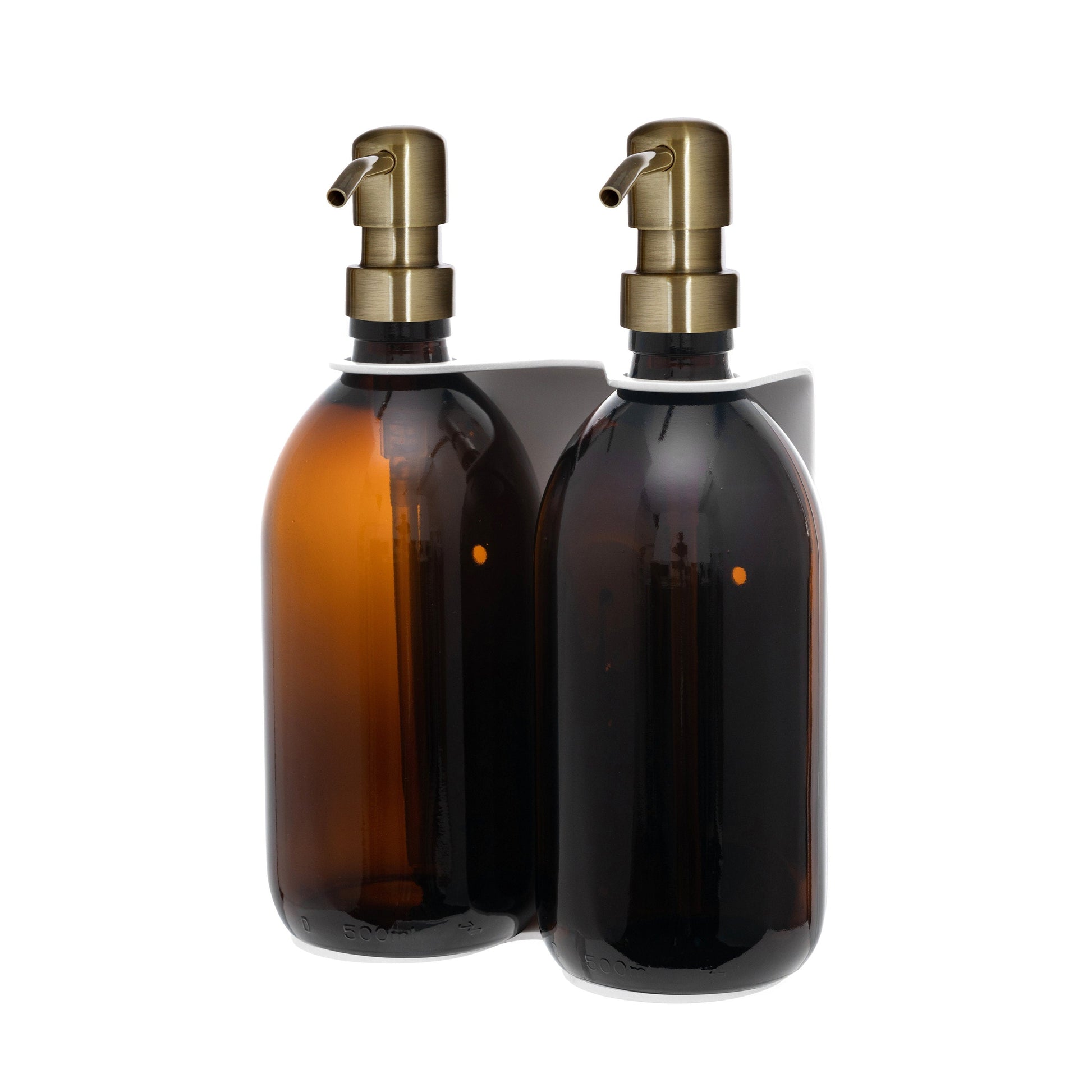 Two glass bottles with brass pumps on a white background