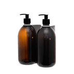 Two brown bottles with black pumps in a white holder on a transparent background