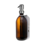 Brown glass bottle with silver pump on a white background
